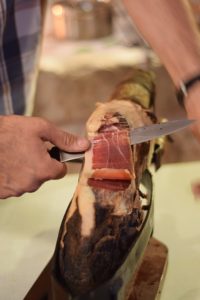 man cutting leg of Iberico ham with a knife