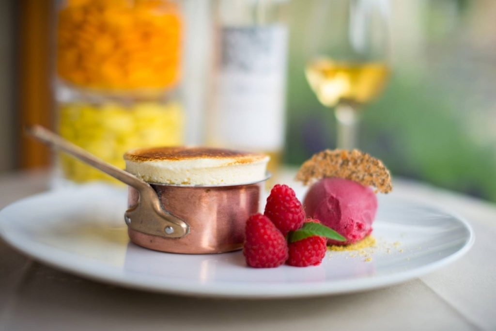 French souffle dessert plated with raspberries and ice cream