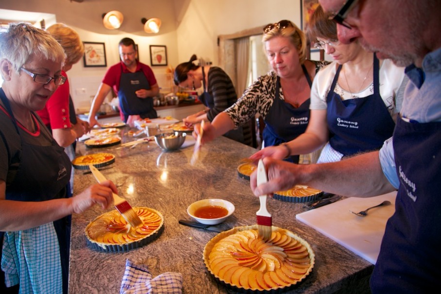 cookery guests glaze their tarts in the French kitchen