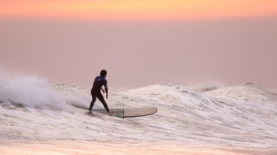 surfer riding the waves at sunset