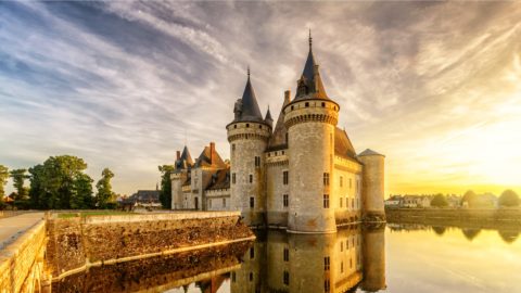 chateau on river at sunset