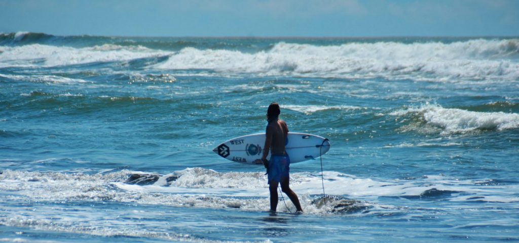 man with a surf board on holiday in costa rica