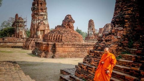 monk in front of temples in thailand