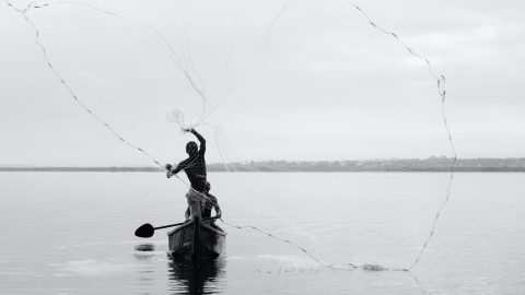 man fishing on a lake in uganda