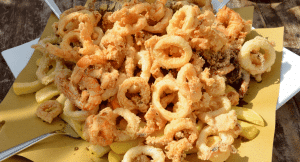 Fritto Misto dish served in a yellow paper on a sunny Italian day