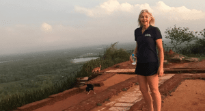 Lydia standing at the top of a mountain in Sri Lanka overlooking a forest
