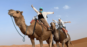 Woman riding a camel through the deserts in Morocco
